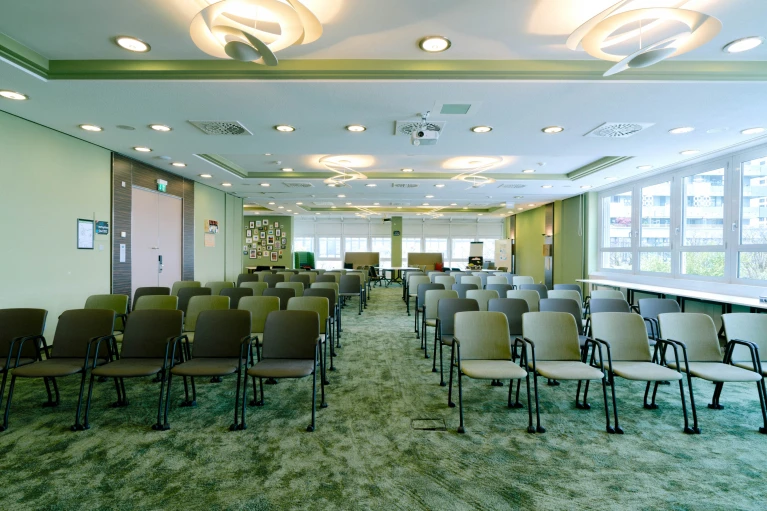 Heller Meetingraum mit Blick auf die Fensterfront, moderner Beleuchtung und Technik im Smartvillage Bogenhausen.